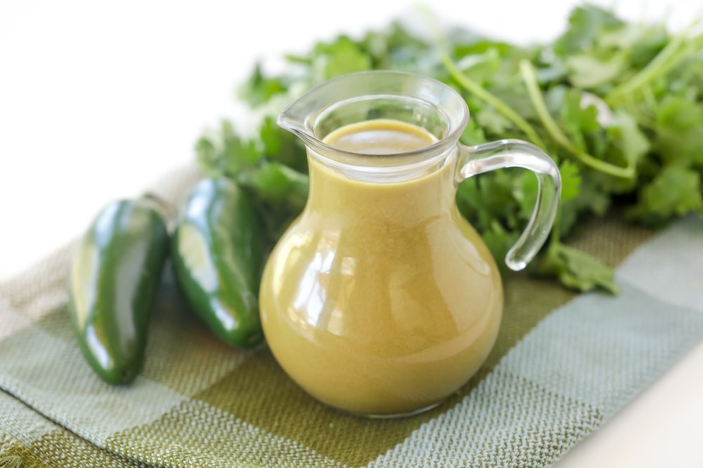 Cilantro lime dressing in a salad dressing carafe.