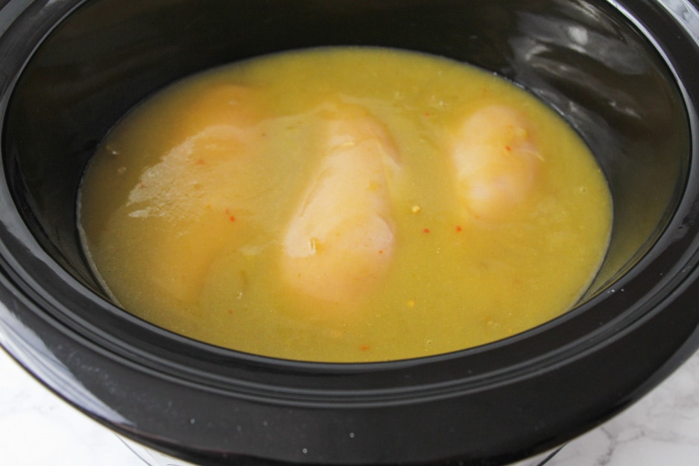 Chicken breasts in crock pot with green enchilada sauce