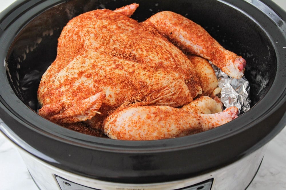 Roast chicken in the crockpot covered in seasoning.
