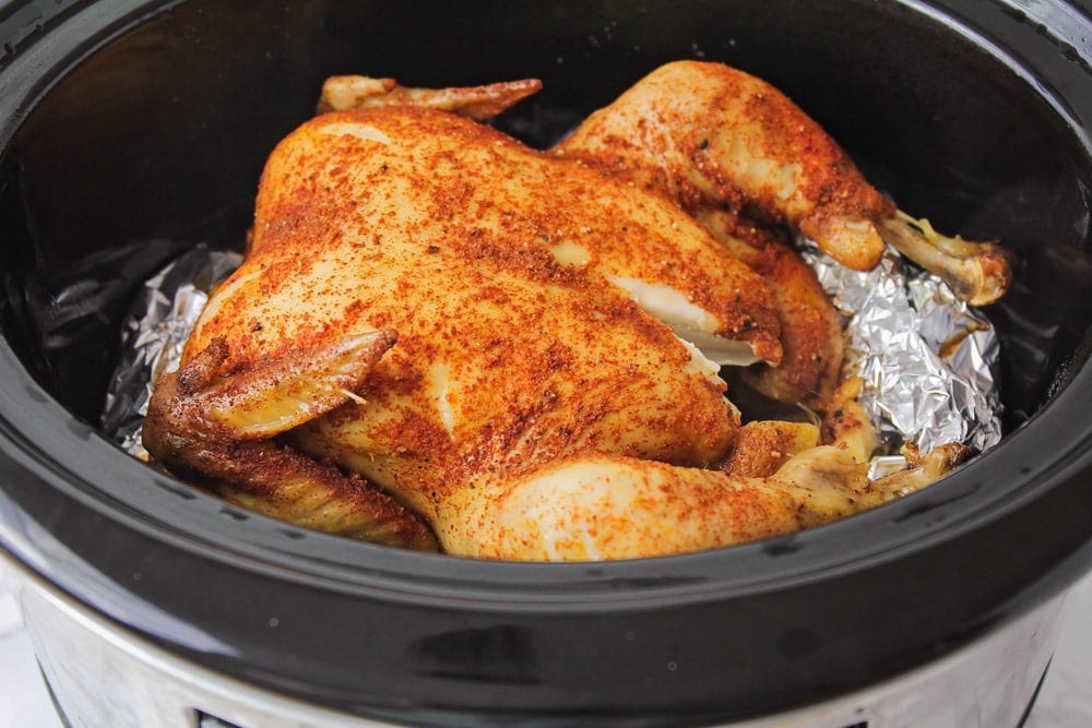 Slow cooker roast chicken in a crock pot.