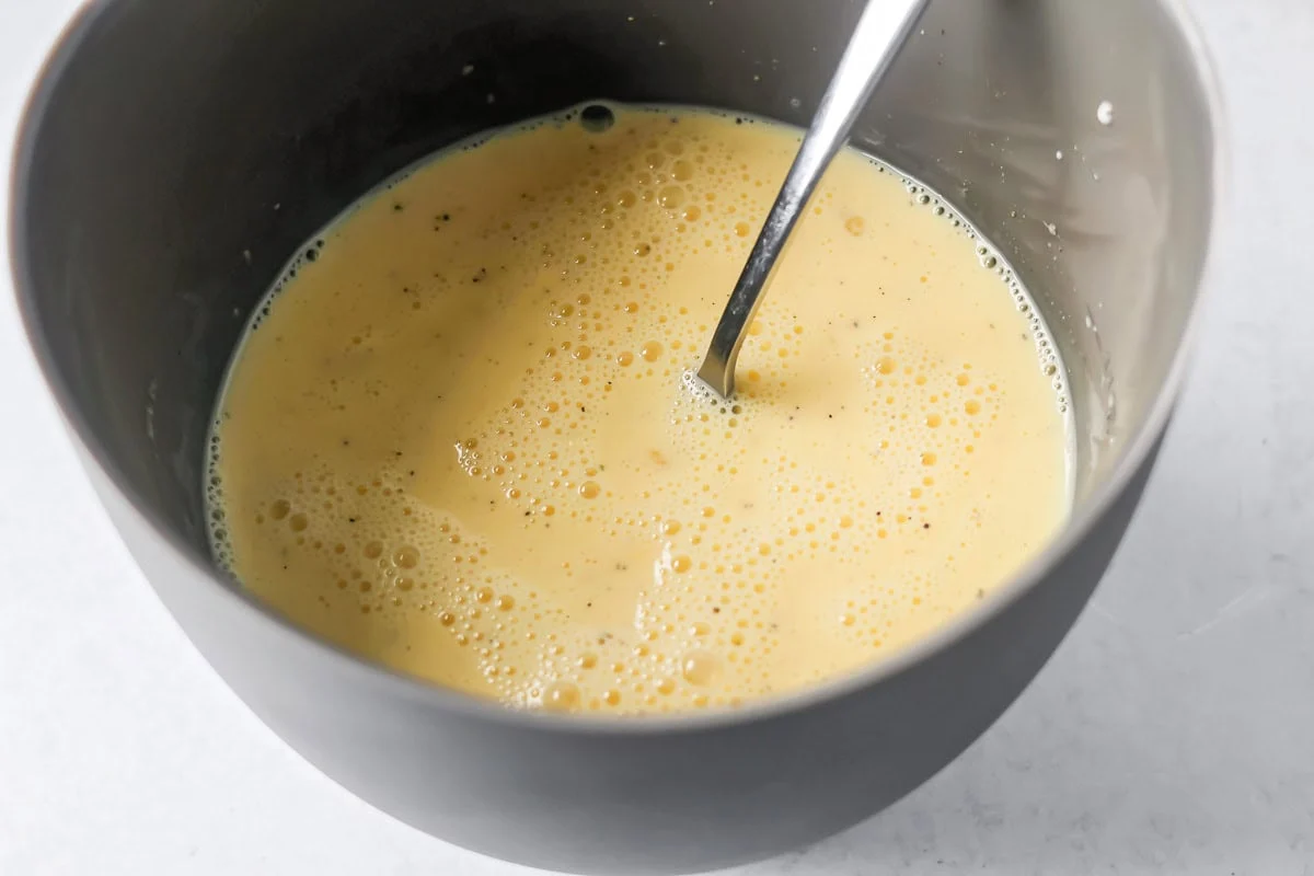 Egg filling for ham and quiche recipe in mixing bowl.