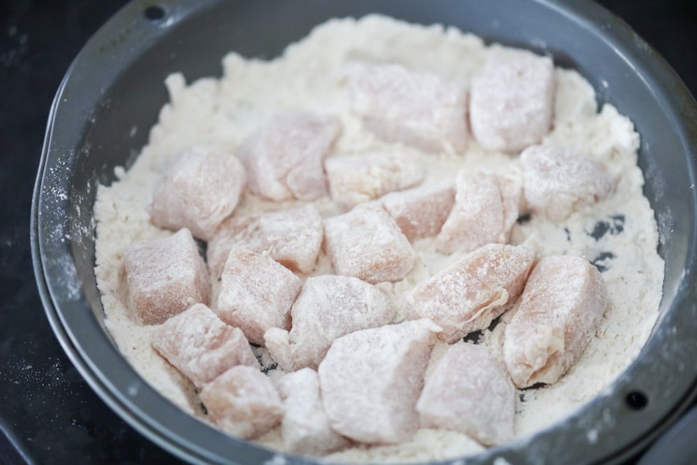 Chicken pieces coated in buttermilk and flour for making popcorn chicken.