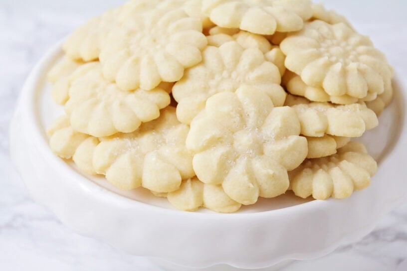 Easy shortbread cookies piled onto a white dessert stand