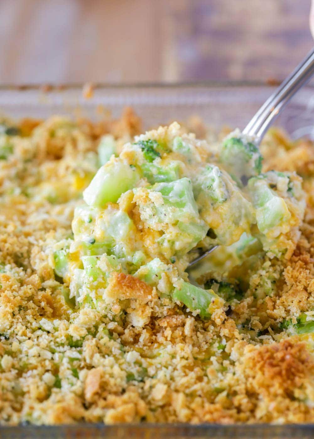 Close up of spoon scooping broccoli and cheese casserole