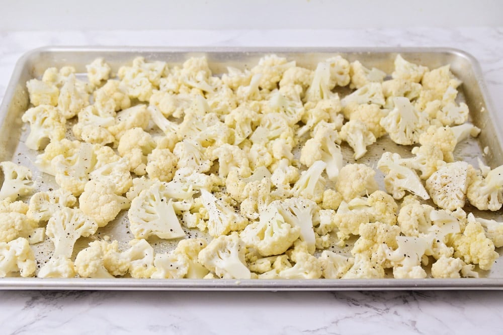Cauliflower on a baking sheet ready to be roasted
