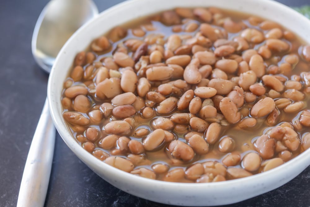 Mexican Christmas food - crock pot pinto beans in a white bowl.