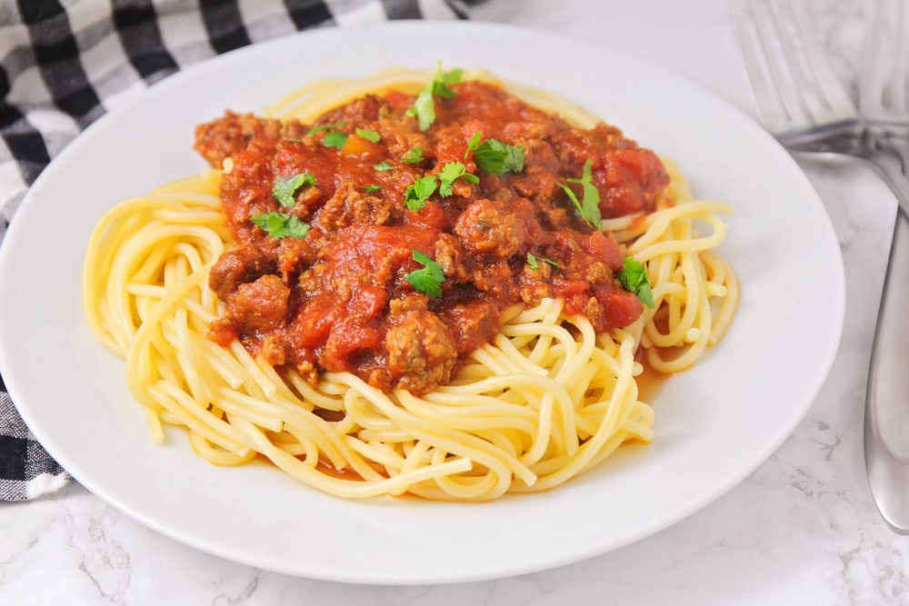 Easy spaghetti pasta served on a white plate.