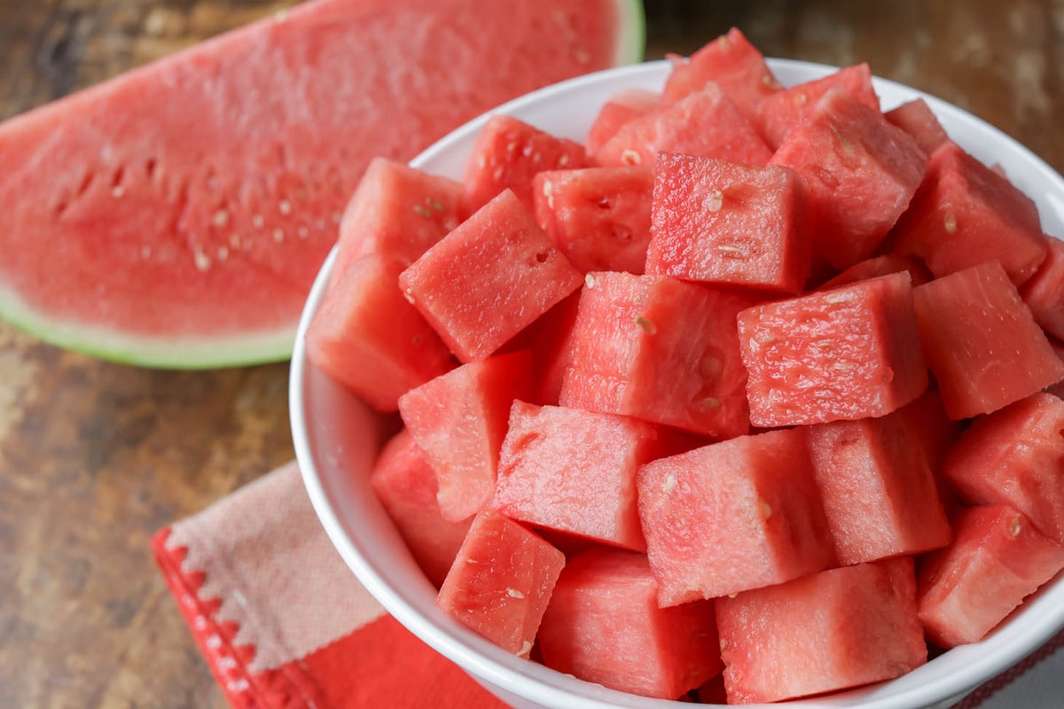 Cubed chunks of watermelon in a white bowl.