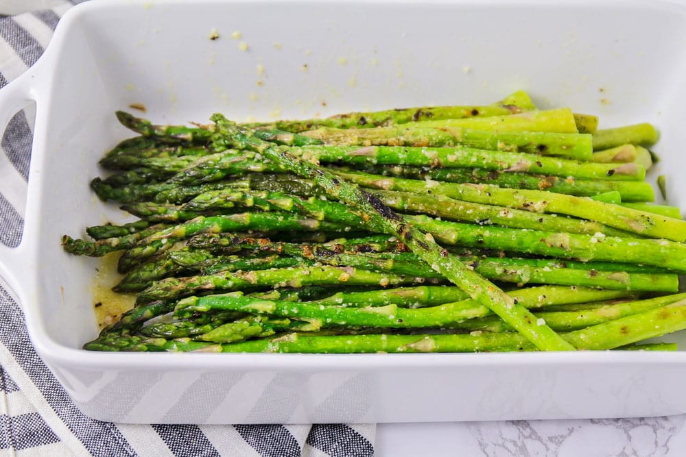 Grilled asparagus in a white serving dish