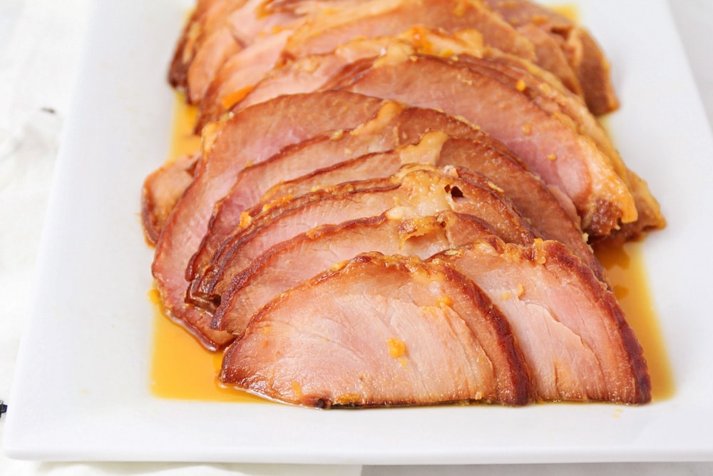 Slices of instant pot ham served on a white platter.