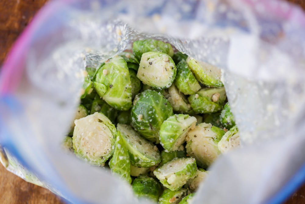 Brussel sprouts coated in oil, seasonings, and parmesan