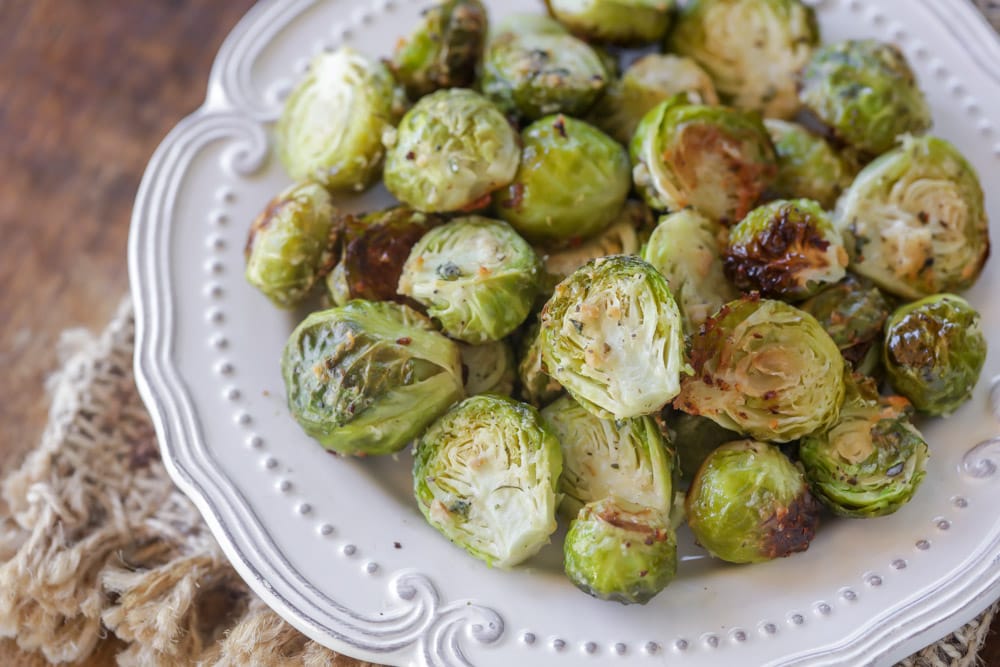 Easy side dishes - parmesan brussel sprouts piled on a white plate.