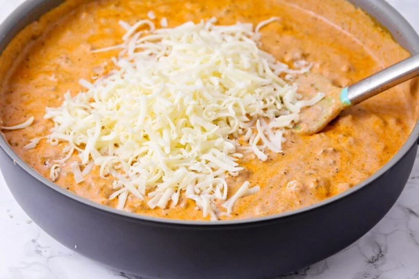 Spaghetti casserole is a comfort-food classic turned cheesy baked pasta dish. It's a deliciously easy way to feed the family! Adding cheese to the spaghetti sauce.