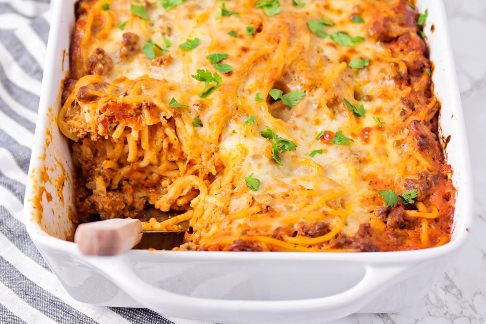 Italian Christmas Dinner ideas - a baking dish of spaghetti casserole with a scoop missing.