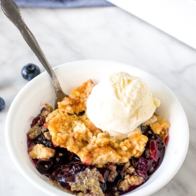 Bowl of blueberry dump cake with a scoop of vanilla ice cream.