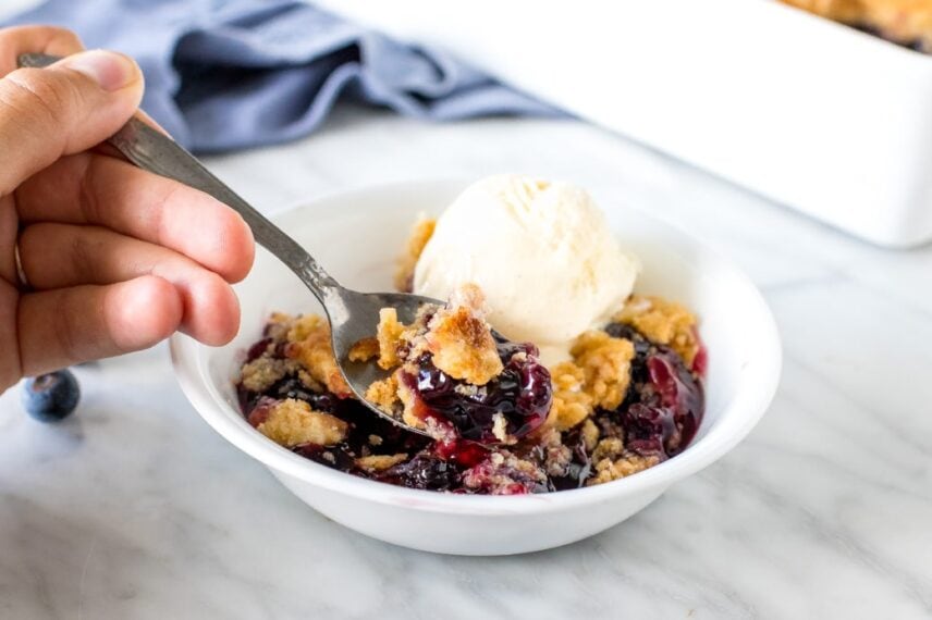 Close up of a spoonfull of blueberry dump cake.