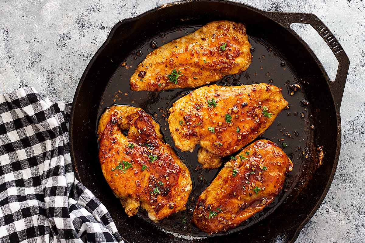 Four Lemon Garlic Chicken Breasts in a cast iron skillet.