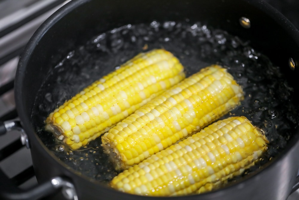 Boiling corn on the cob in a pot on the stove