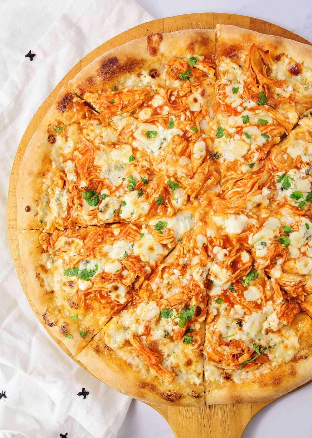 Close up of buffalo chicken pizza recipe on a pizza peel.
