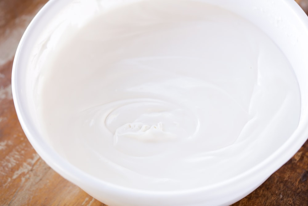 Creaming pudding mixture in a white bowl.