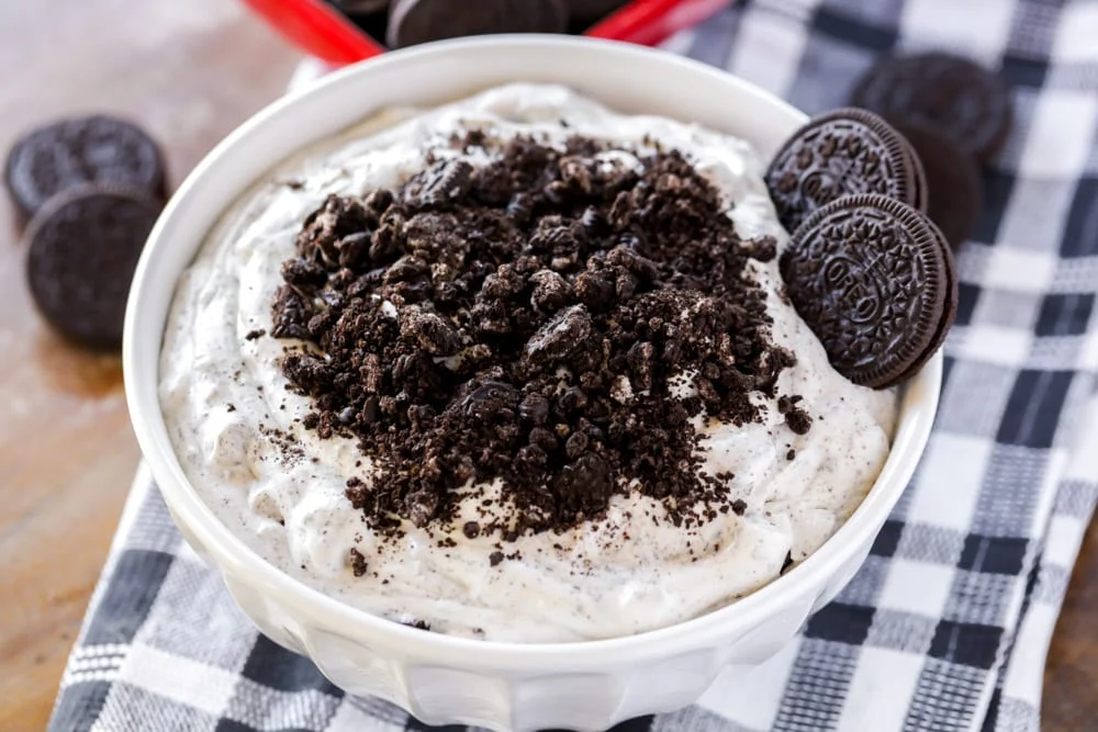 Oreo fluff in a white bowl topped with crushed oreo.