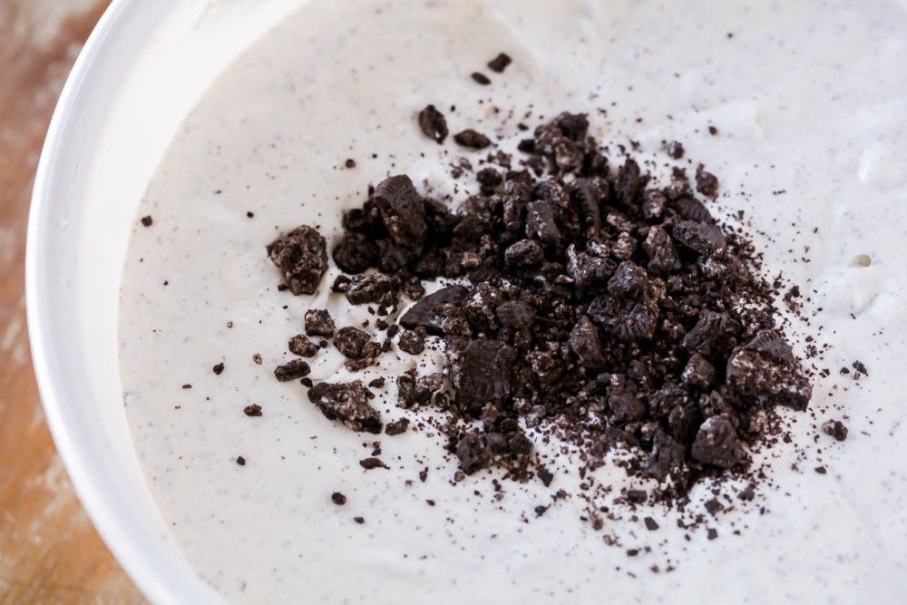 Adding crushed Oreos to pudding mixture.