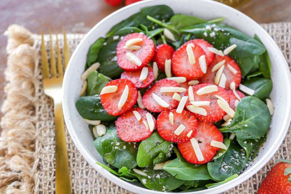 Strawberry spinach salad served in a white bowl.