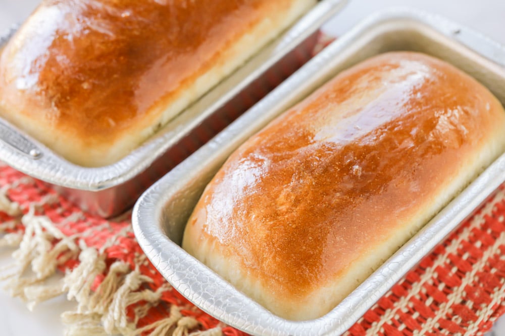 Two loafs of baked bread with melted butter on top