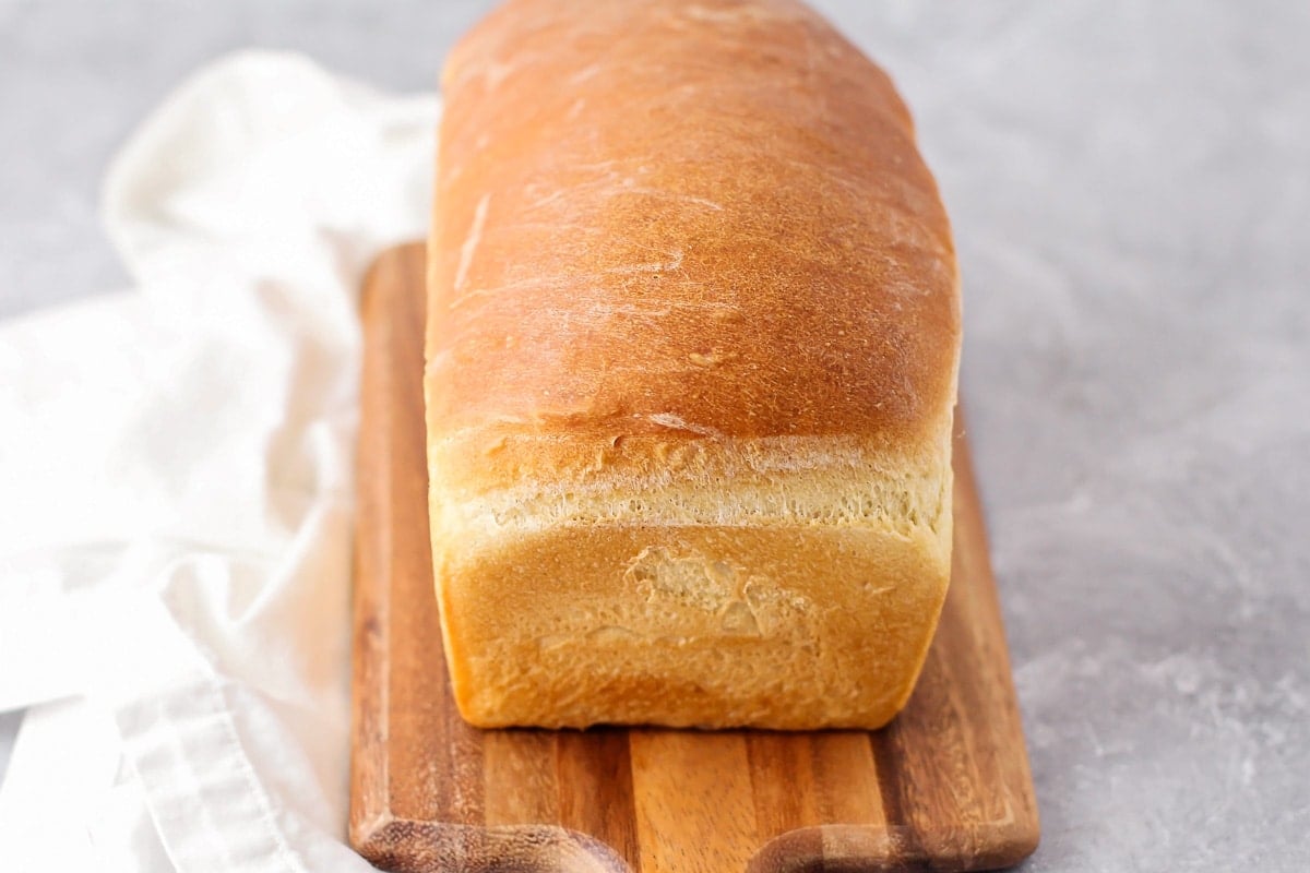 Easy homemade white bread loaf on a wooden cutting board.