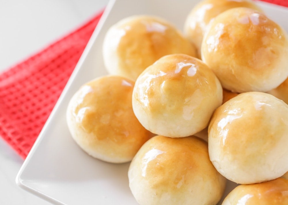Yeast bread recipes - easy yeast rolls piled on a white plate.