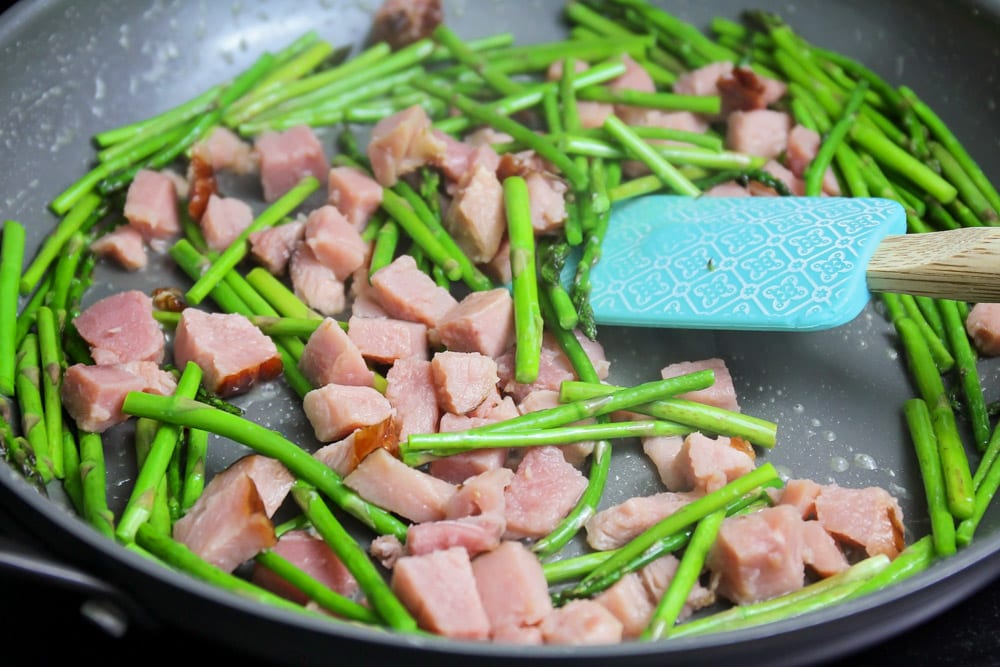 Ham and asparagus being sautéed for frittata recipe