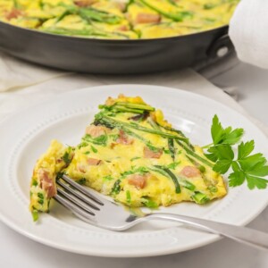 A slice of frittata served on a white plate.