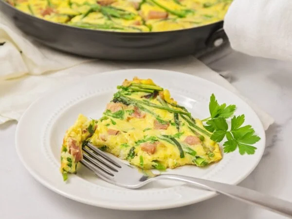A slice of frittata served on a white plate.