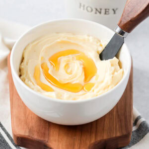 Honey butter in bowl with honey drizzled on top.
