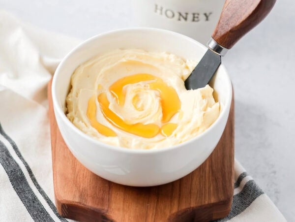 Honey butter in bowl with honey drizzled on top.