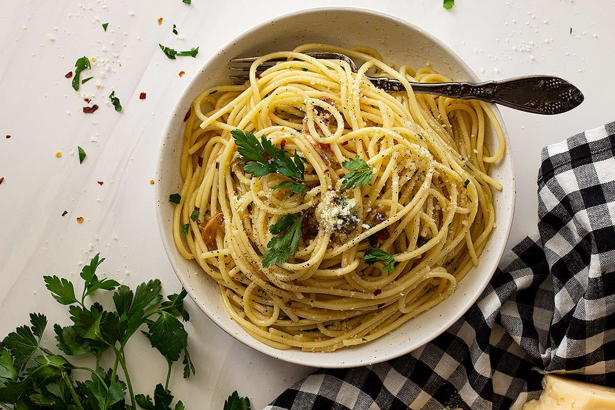 Spaghetti Aglio e Olio topped with parmesan cheese in a bowl
