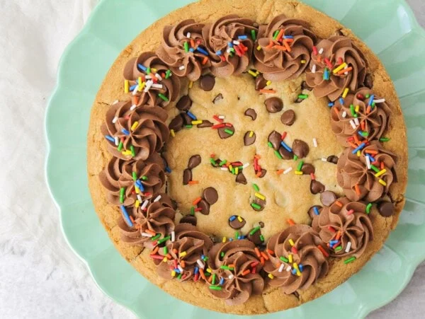 A chocolate chip cookie cake topped with frosting.