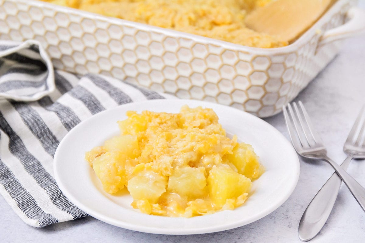 A scoop of pineapple casserole served on a white plate.