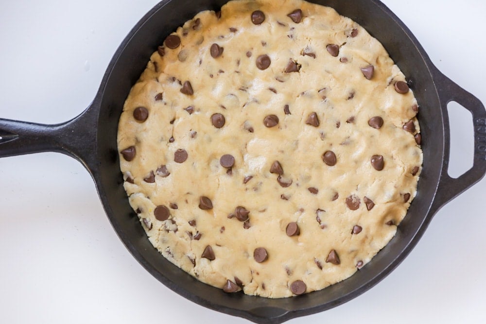 Pizookie cookie dough pressed in an iron skillet.