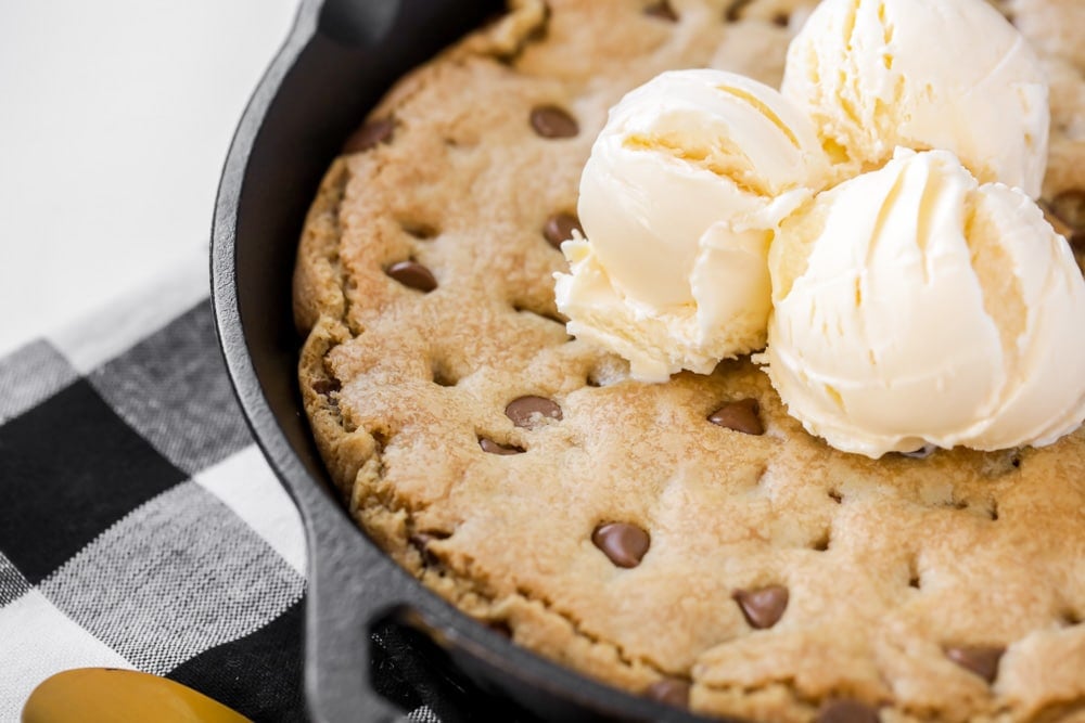 Pizookie recipe close up with three scoops of vanilla ice cream on top.