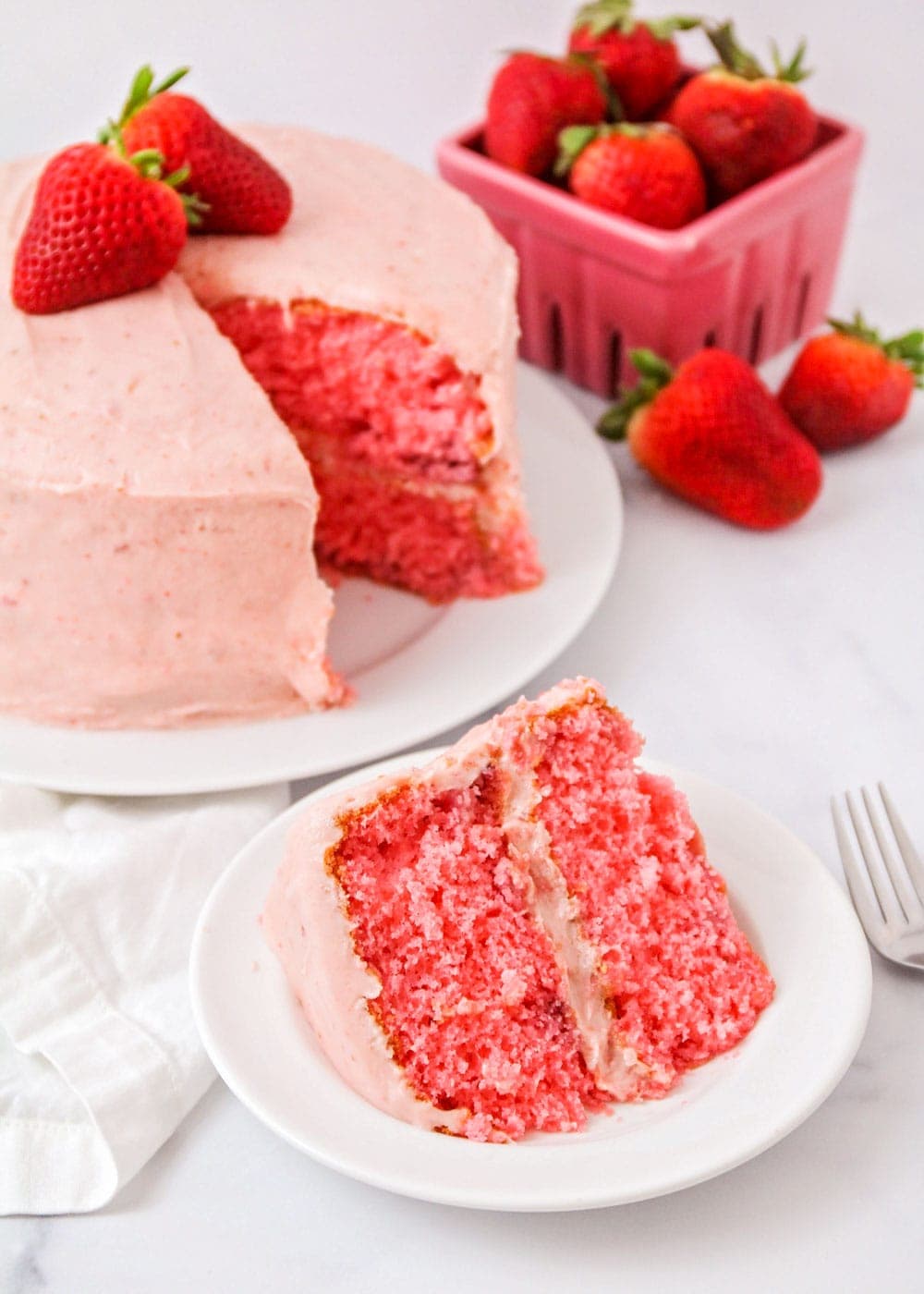 A slice of homemade strawberry cake on a white plate.