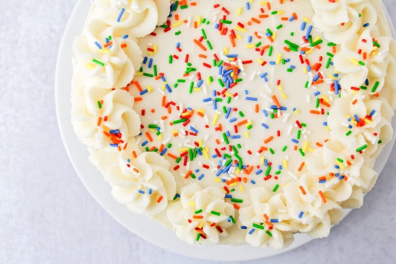 The top view of a vanilla cake topped with sprinkles.