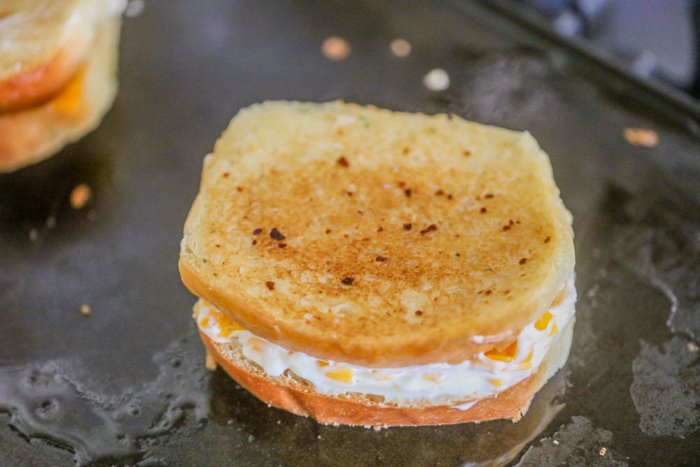 Ultimate grilled cheese cooking on a griddle