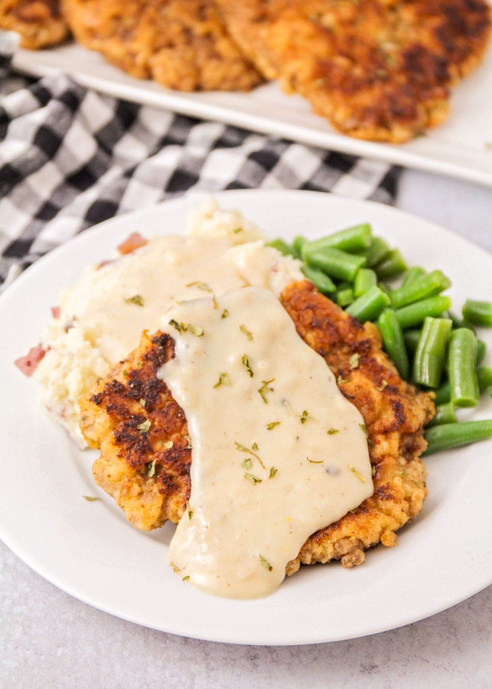 Close up of chicken fried steak covered with gravy.