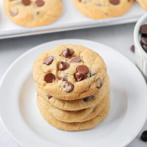 Eggless chocolate chip cookies stacked on each other on white plate.