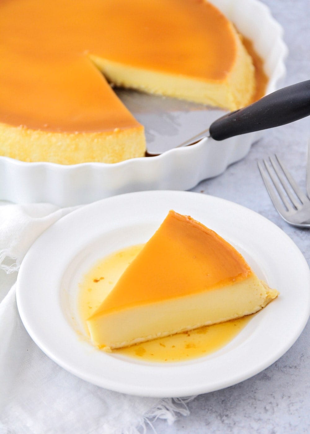 Close up of a how to make flan. A slice served on a white plate.