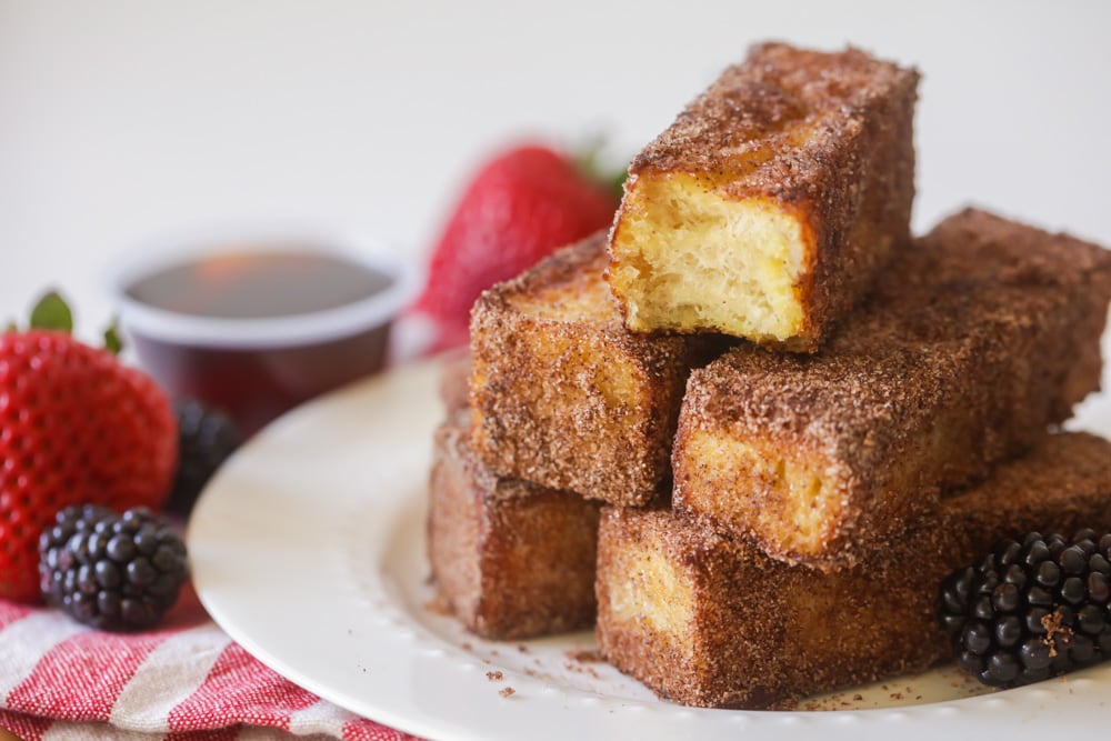 A stack of French Toast Sticks served on a white plate.