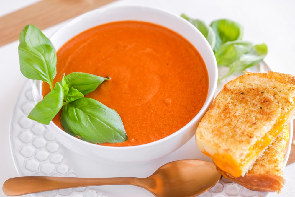 Easy Dinner Ideas - Grilled cheese and tomato soup served together on a white plate.