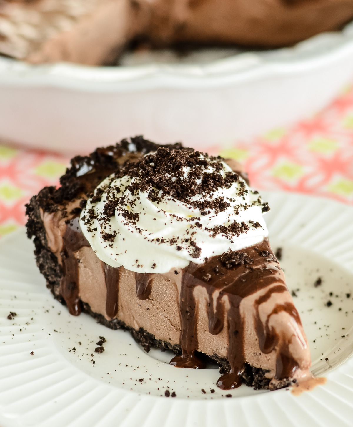 Mud pie recipe sliced and topped with whipped cream and chocolate sauce.