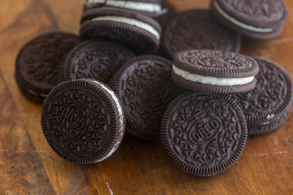 Oreo cookies on a wooden cutting board.